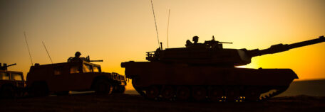 War Concept. Military silhouettes fighting scene on war foggy sky background at sunset. Armored vehicles with soldiers ready to attack. Artwork decoration. Selective focus